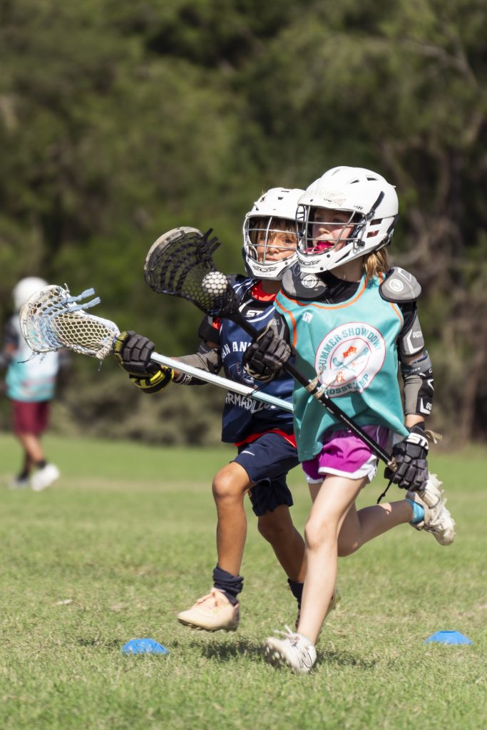 A young lacrosse player in full gear during a game