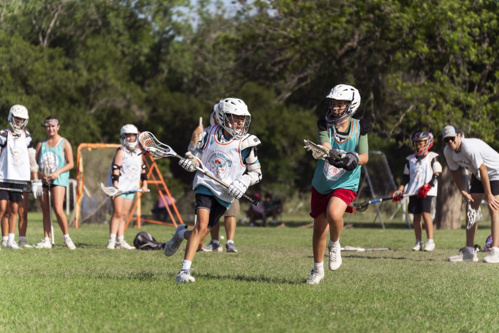 Young lacrosse players lined up on the field