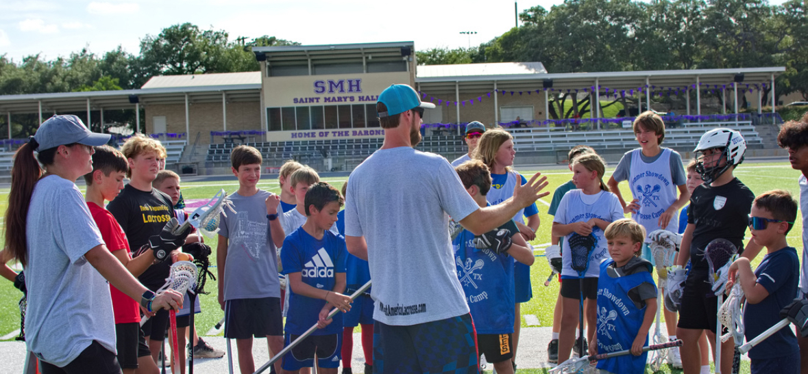 Coach Paul Taylor coaching a large group of youth lacrosse players at Summer Showdown Camp in San Antonio