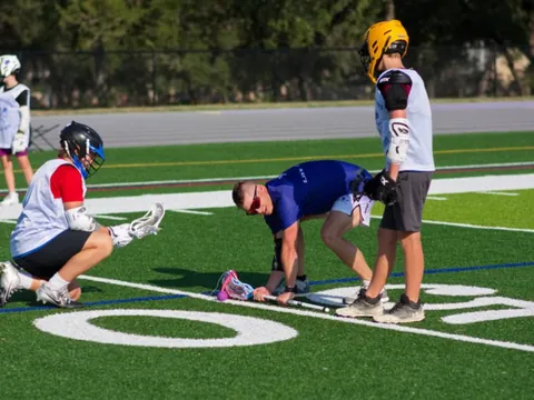 Two youth lacrosse players lining up for a faceoff at a San Antonio clinic