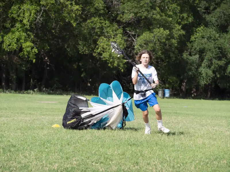 Young lacrosse player training with a speed parachute in San Antonio