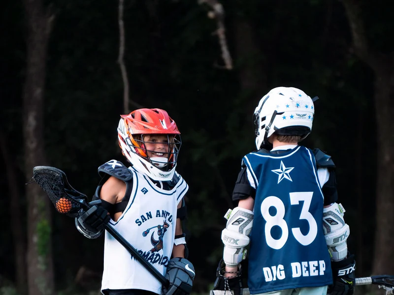Two young lacrosse teammates on the field in San Antonio