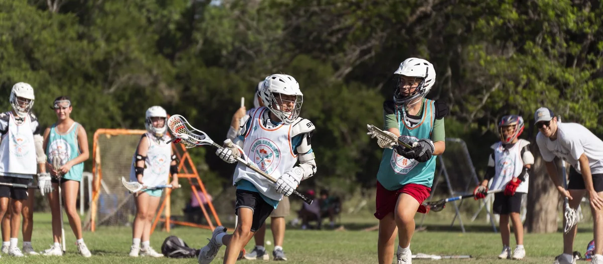 Youth lacrosse game action at a Great American Lacrosse camp in San Antonio