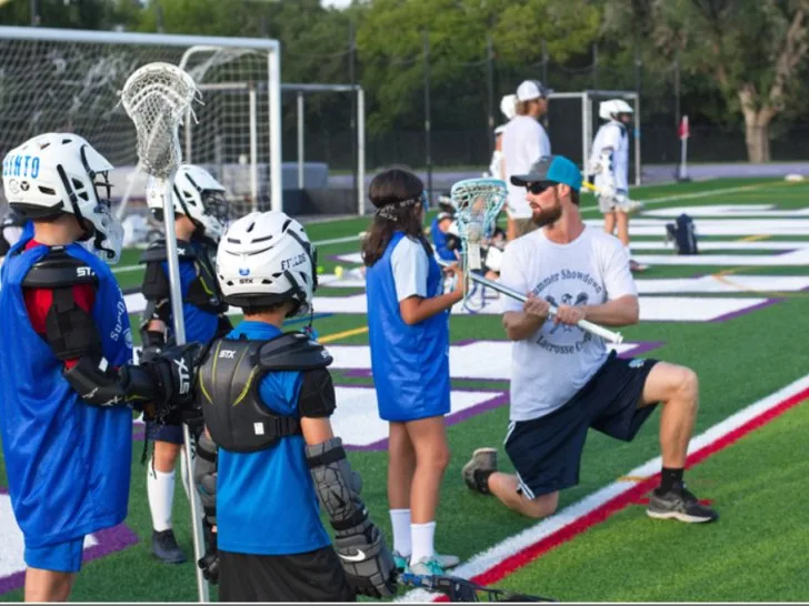 Coach Paul Taylor working one-on-one with a young lacrosse player in San Antonio